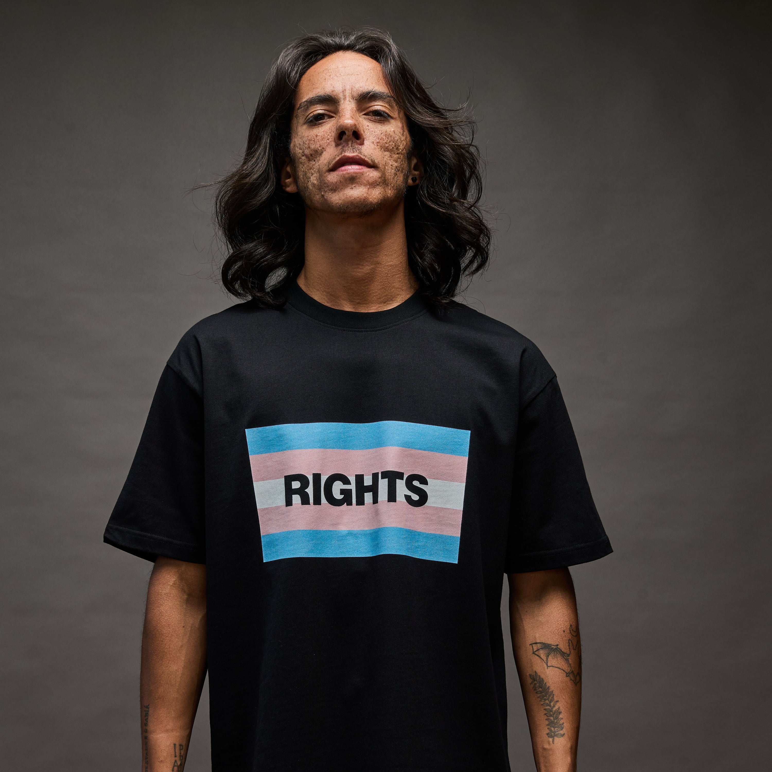 Person wearing a black t-shirt with a trans pride flag and the word 'RIGHTS'.