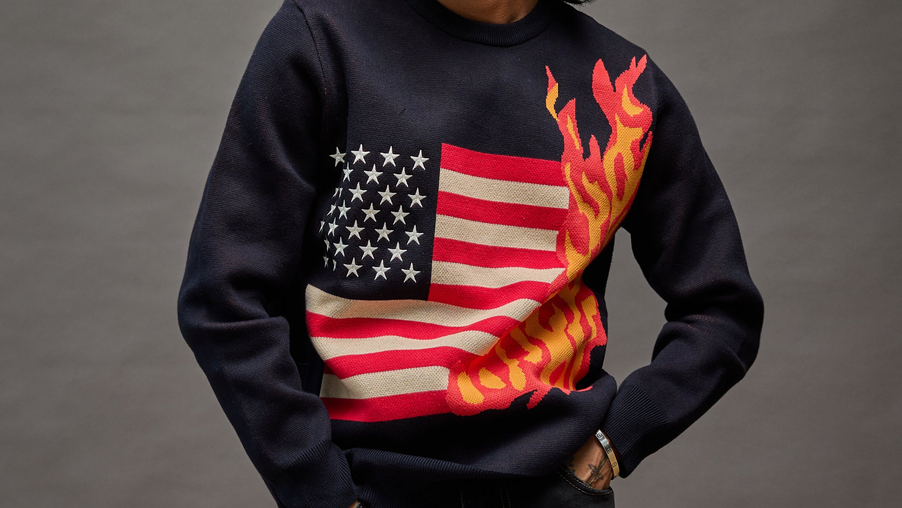 “Model wearing Cola Corporation 1A Sparks navy blue burning flag sweater outfit”